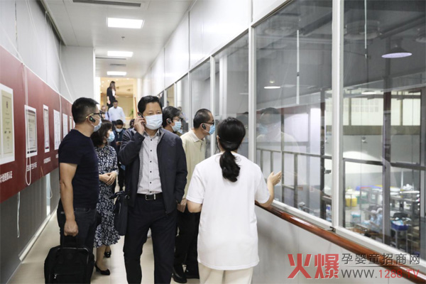 媒体代表隔玻璃窗参观无尘车间.jpg